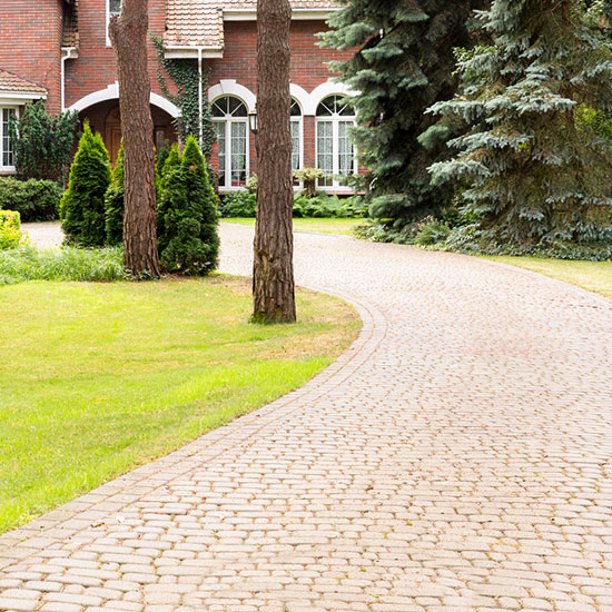 A stone driveway leading up to large home